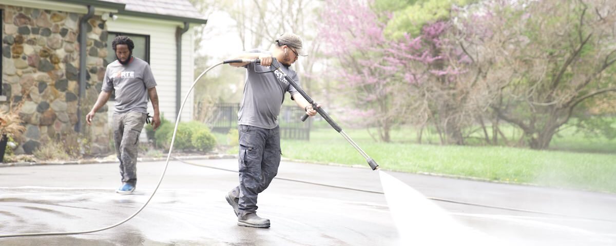 forte surfaces team pressure washing a concrete driveway
