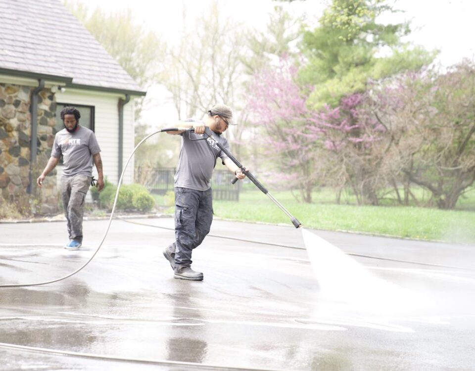 forte surfaces team pressure washing a concrete driveway