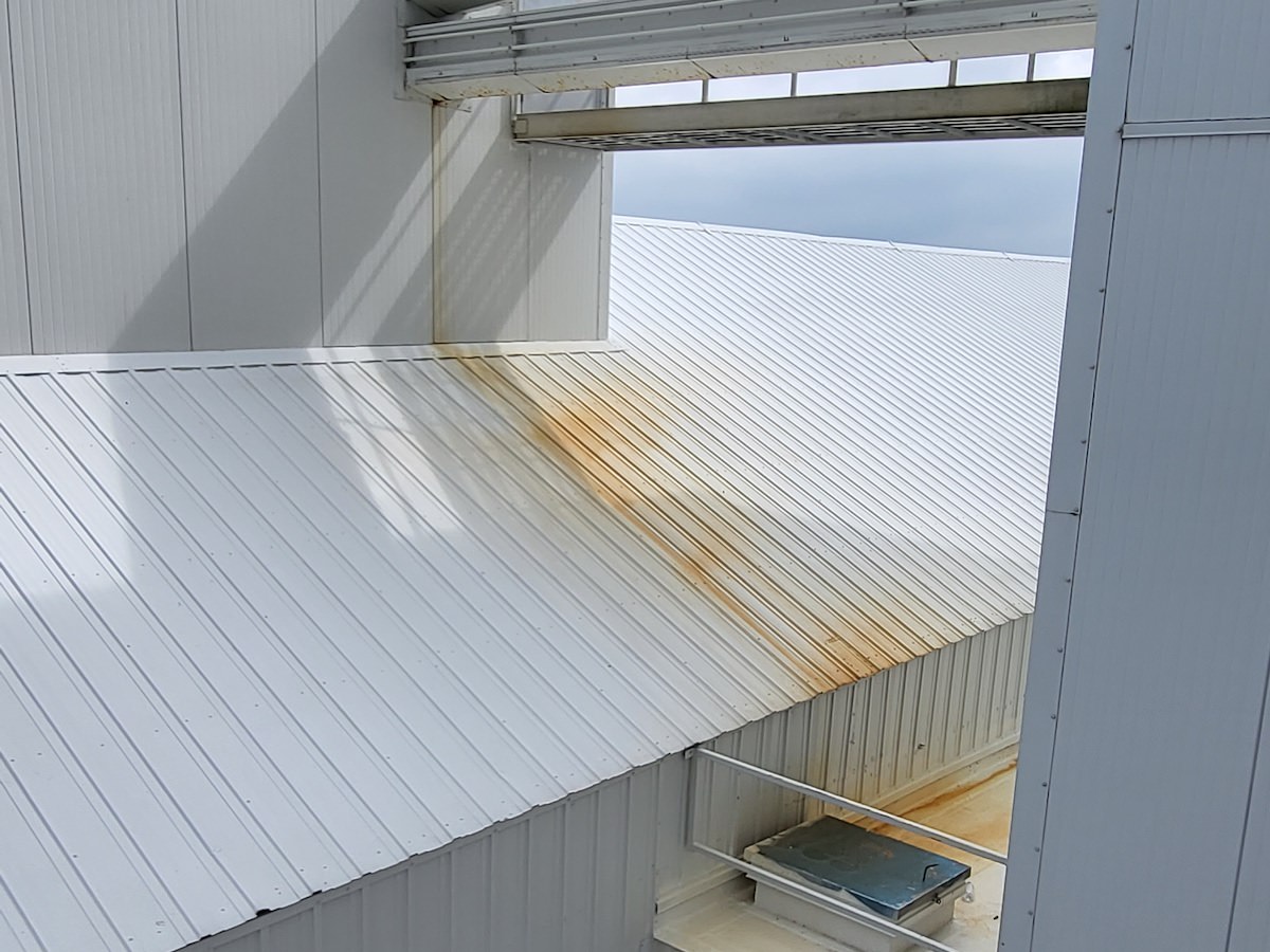 a white metal roof with a rust stain on it