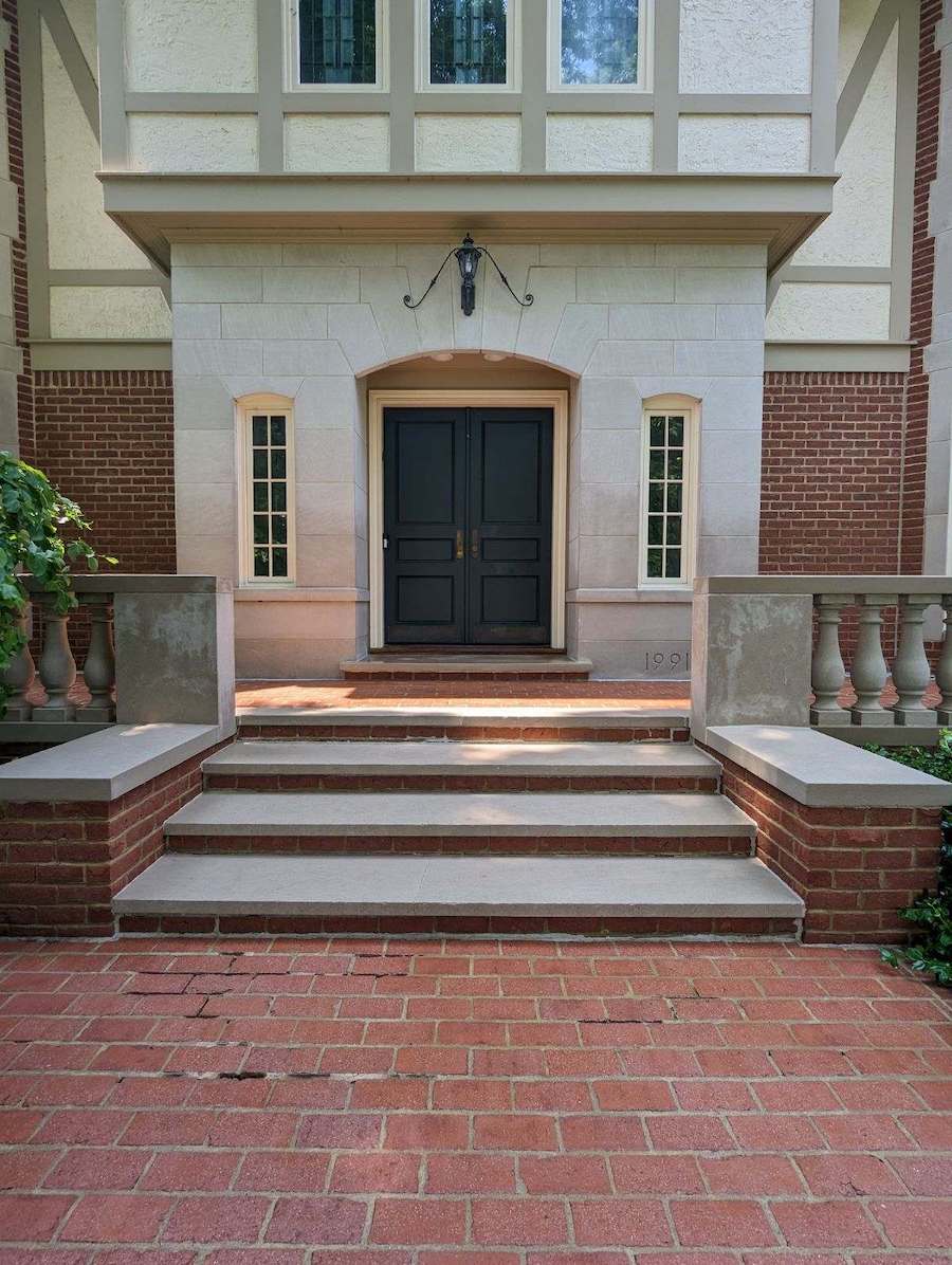 a clean brick walkway leading to the front door of a house