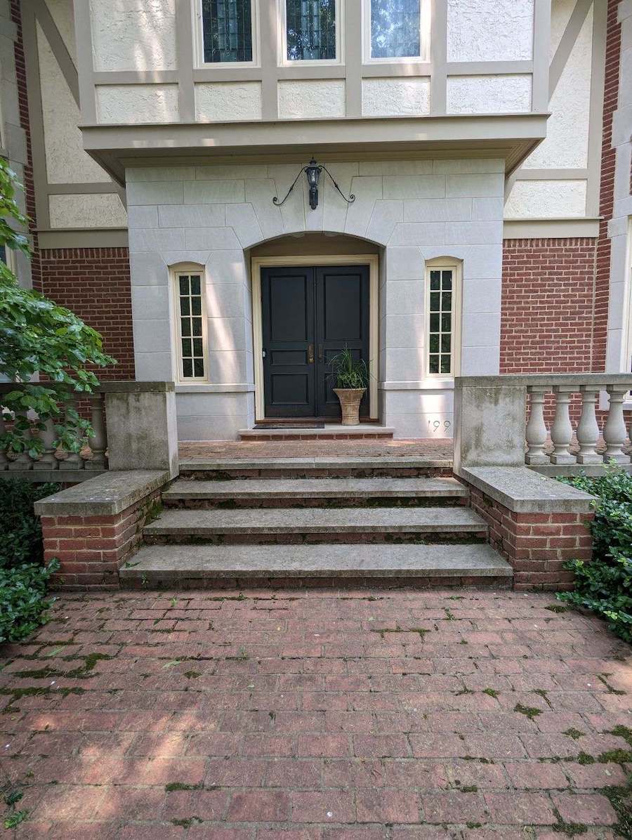 the front door of a brick house with a black door