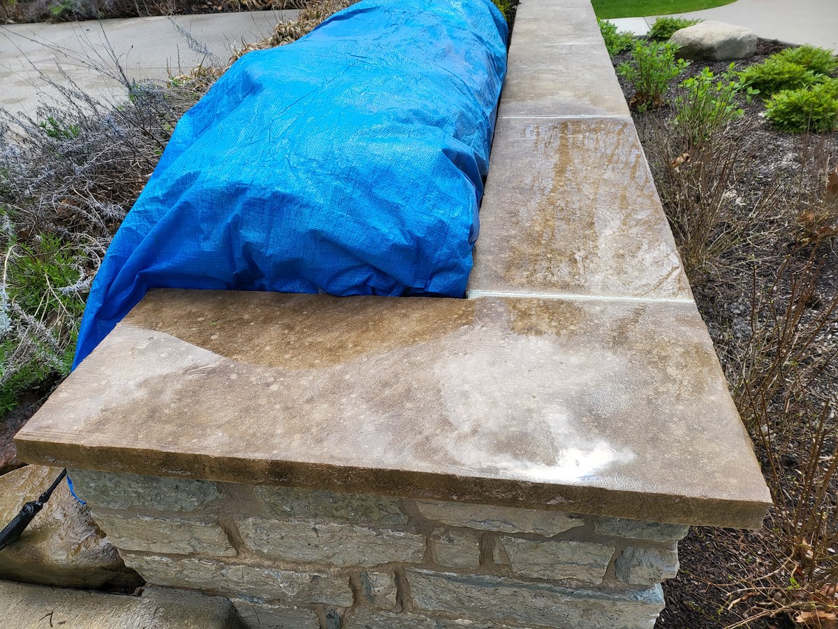 a blue tarp is sitting on top of a stone wall