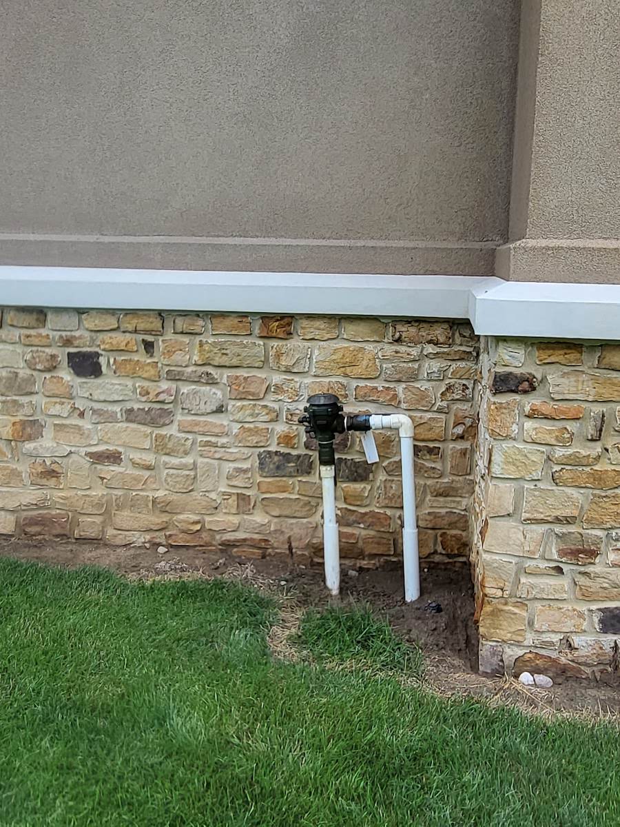a stone wall with a pipe attached to it that was freshly cleaned