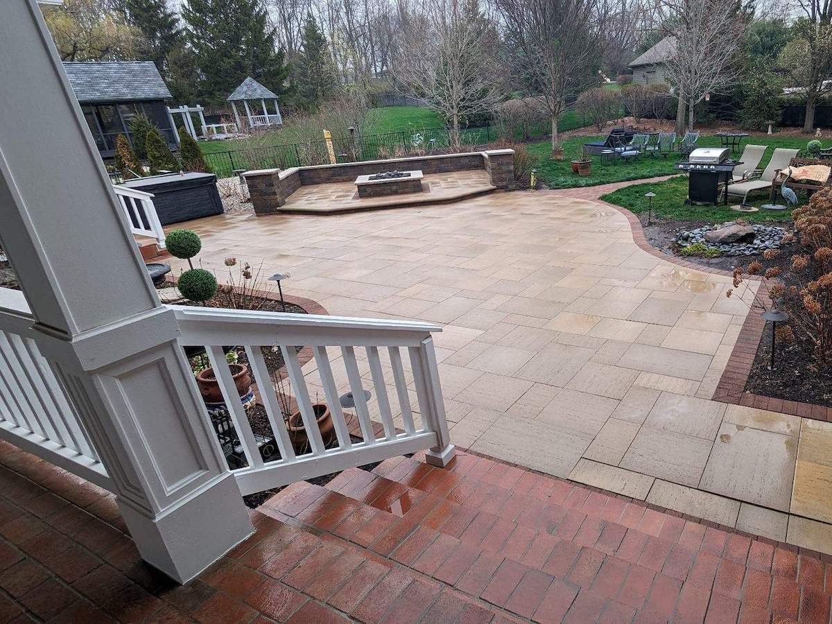 a clean brick patio with a wooden fence in the background