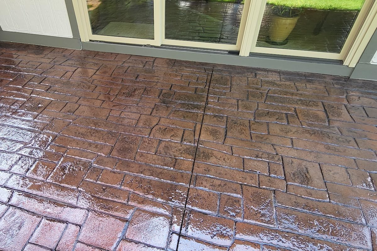 a stone patio with a sliding glass door in the background