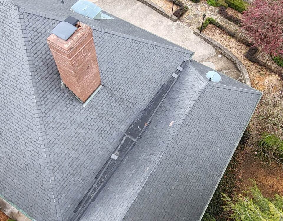 an aerial view of a house with a chimney on the roof that was washed