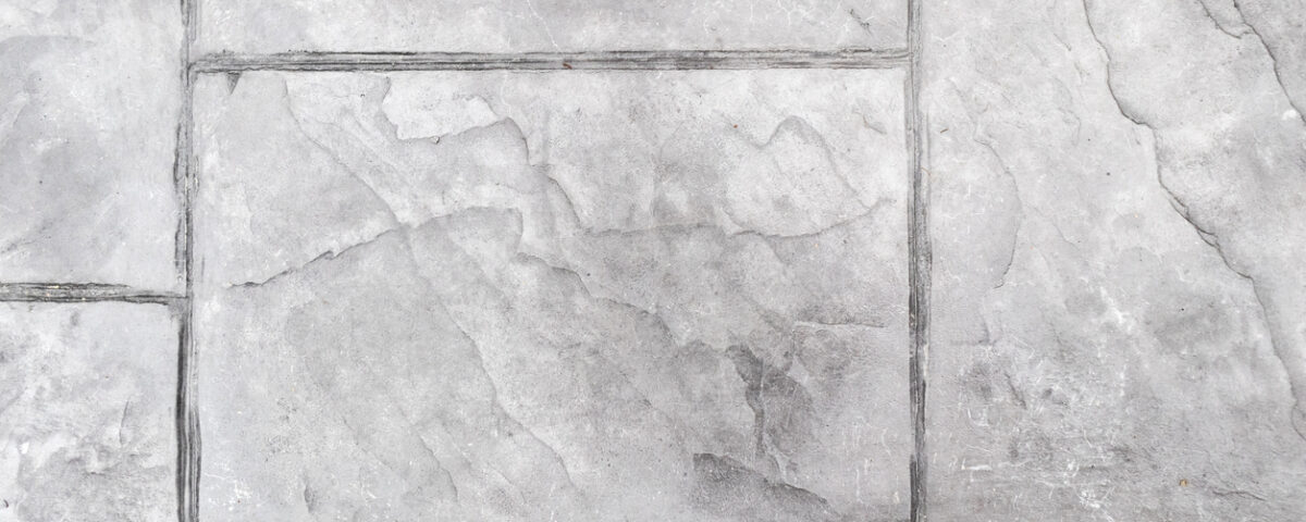 a close up of a gray tile floor with dirty grout
