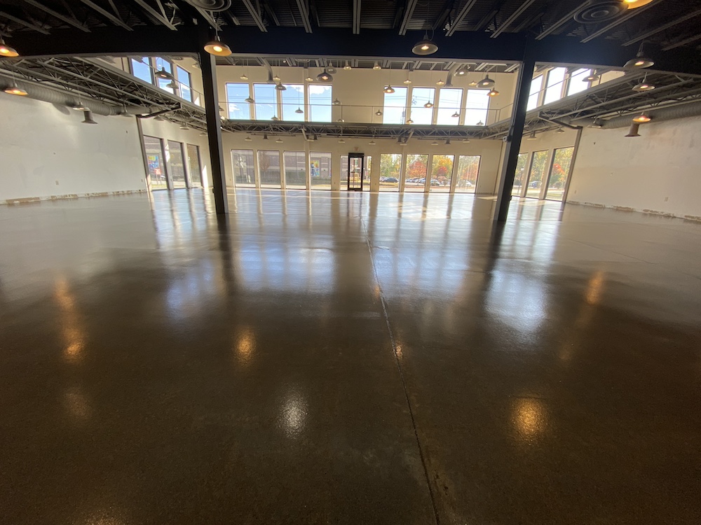a large empty room with a lot of windows that recently had an epoxy floor installed